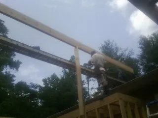 Carpenter setting a ridge beam over a new addition frame — Ice Dam Removal by Roofing Brothers in Sudbury