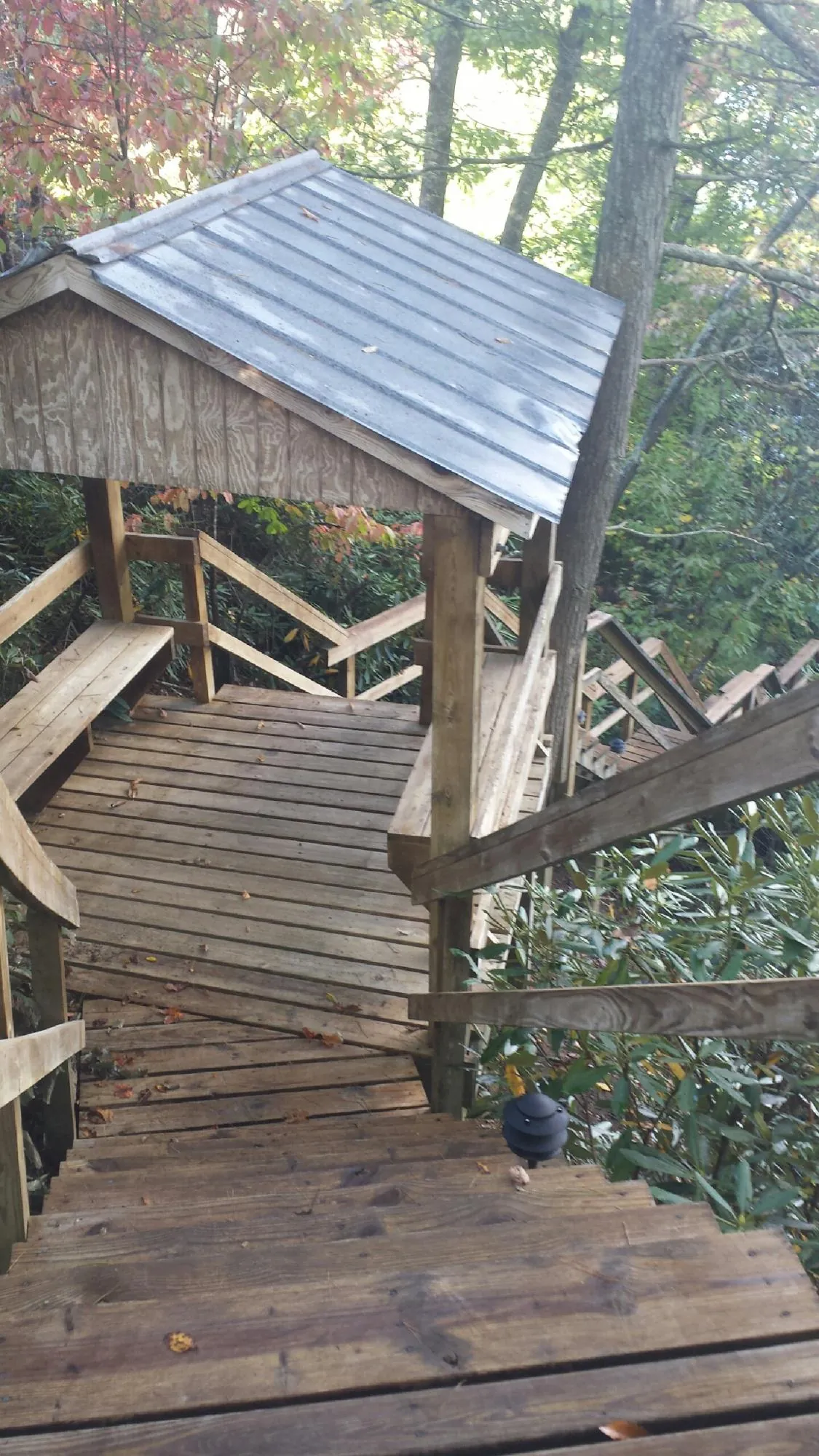Metal roofed shelter over wooden steps on a wooded walkway — Skylight Repair & Installation work by our crew in Sudbury