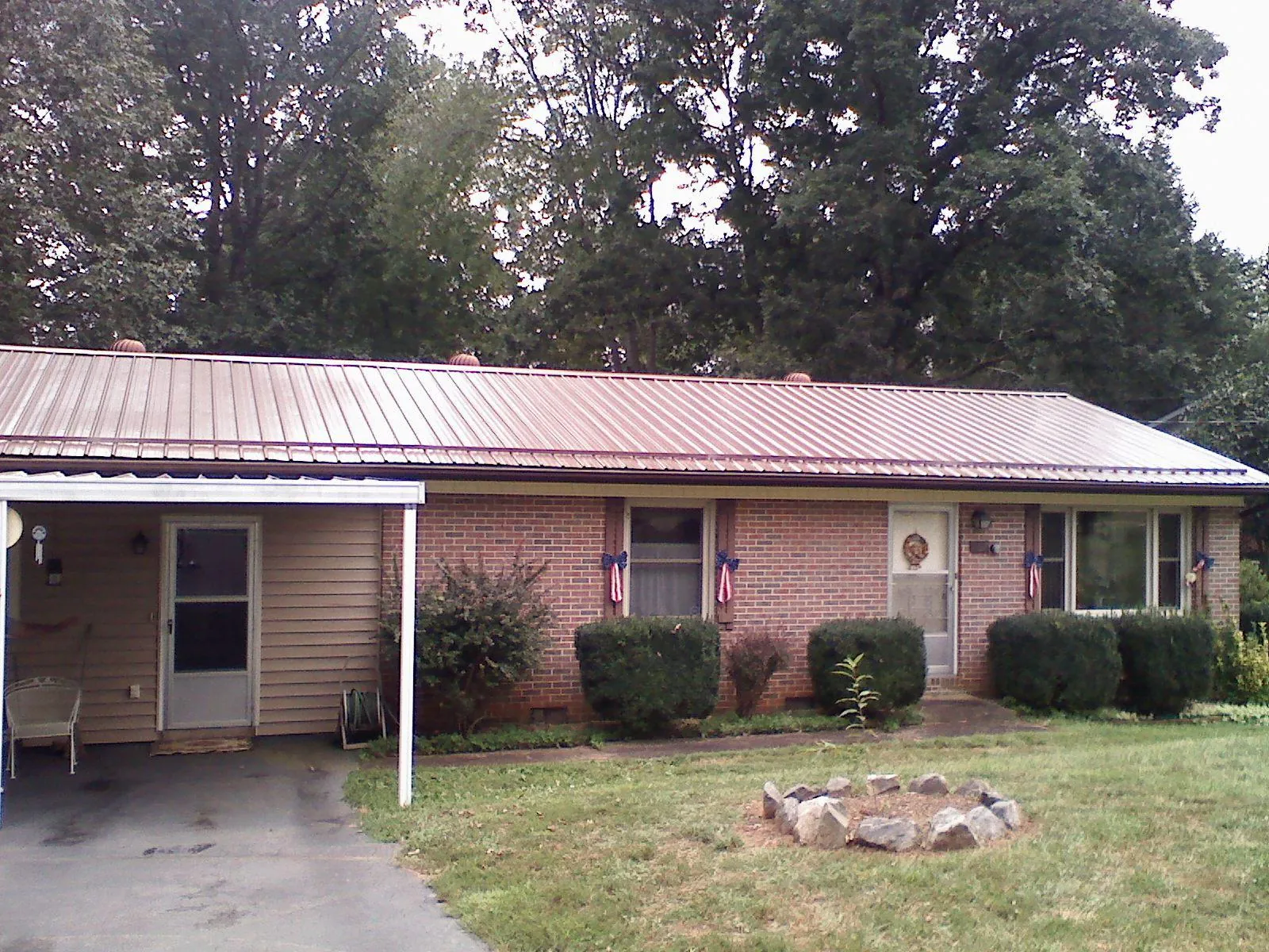Bronze metal roof and carport on a brick ranch home — Roof Repair work by our crew in Sudbury
